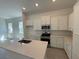 Modern kitchen featuring white cabinetry, stainless steel appliances, and a center island at 931 Azalea Walk Cir, Deland, FL 32724