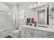 Modern bathroom featuring white cabinets, sleek fixtures, and a glass-enclosed shower-tub combination at 10829 Royal Cypress Way, Orlando, FL 32836