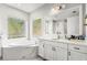 Bright bathroom with double vanity, garden tub, and large window at 10829 Royal Cypress Way, Orlando, FL 32836