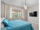 Comfortable bedroom featuring cozy blue bedding, plush carpeting, and a large window offering natural light and views at 10829 Royal Cypress Way, Orlando, FL 32836