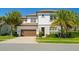 A stunning two-story home with lush landscaping and a brick driveway create great curb appeal at 10829 Royal Cypress Way, Orlando, FL 32836