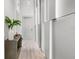 Modern hallway with wood floors, custom paneling, and accent lighting is sleek and inviting at 10829 Royal Cypress Way, Orlando, FL 32836