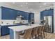 Modern kitchen with blue cabinets, stainless steel appliances, large island with seating, and stylish countertops at 10829 Royal Cypress Way, Orlando, FL 32836