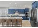 Modern kitchen featuring blue cabinets, stainless steel appliances, a large island with seating, and wood-look tile flooring at 10829 Royal Cypress Way, Orlando, FL 32836
