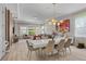 Bright and open living room with hardwood floors, dining table, and large windows for natural light at 10829 Royal Cypress Way, Orlando, FL 32836