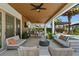 Large covered patio with outdoor seating, kitchen, and ceiling fan at 10829 Royal Cypress Way, Orlando, FL 32836
