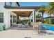 Covered patio with outdoor seating, bar, and outdoor kitchen by the pool at 10829 Royal Cypress Way, Orlando, FL 32836