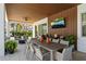 Outdoor seating area with a long table, outdoor kitchen, and ceiling fan at 10829 Royal Cypress Way, Orlando, FL 32836