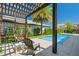 Stylish pool area with a pergola-covered lounge, offering a private outdoor retreat surrounded by lush greenery at 10829 Royal Cypress Way, Orlando, FL 32836