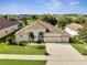 Beautiful house with a three-car garage, lush green lawn, and mature landscaping in a desirable neighborhood at 10955 Lemay Dr, Clermont, FL 34711