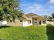 Backyard featuring a well-maintained lawn with a large home and patio at 10955 Lemay Dr, Clermont, FL 34711