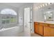 Bathroom features a soaking tub with window, and vanity at 10955 Lemay Dr, Clermont, FL 34711