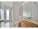 Bathroom with walk-in shower, wood vanity and light sconce above the mirror at 10955 Lemay Dr, Clermont, FL 34711