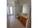 Bathroom featuring a wood vanity, mirror, tile floors, and glass-enclosed shower at 10955 Lemay Dr, Clermont, FL 34711