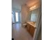 Bright bathroom featuring a wood vanity, tile floors, and a glass-enclosed shower at 10955 Lemay Dr, Clermont, FL 34711