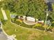 Aerial view of the community entrance sign, framed by manicured landscaping and lush greenery at 10955 Lemay Dr, Clermont, FL 34711