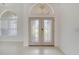 Welcoming front entrance featuring decorative double doors, arched transom window, and tiled flooring at 10955 Lemay Dr, Clermont, FL 34711