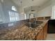 Kitchen featuring a sink, faucet, granite countertops, and wood cabinets at 10955 Lemay Dr, Clermont, FL 34711