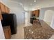 Well-lit kitchen featuring stainless appliances, tile floors, and granite countertops at 10955 Lemay Dr, Clermont, FL 34711
