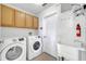 Well-equipped laundry room with modern appliances, utility sink, and ample cabinet space at 10955 Lemay Dr, Clermont, FL 34711
