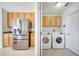Adjacent laundry room featuring a stainless refrigerator, and modern washer and dryer at 10955 Lemay Dr, Clermont, FL 34711