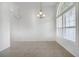 Bright living room with tile flooring, baseboards, chandelier, and large arched window at 10955 Lemay Dr, Clermont, FL 34711