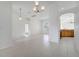 Open concept living room features neutral tile flooring, chandelier, and eat-in kitchen at 10955 Lemay Dr, Clermont, FL 34711