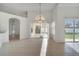 Open-concept living room featuring tile floors, vaulted ceilings, and sliding door access to the patio at 10955 Lemay Dr, Clermont, FL 34711