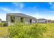 Lush green backyard and covered patio provide a peaceful outdoor setting for relaxation and enjoyment at 1257 Champions Dr, Daytona Beach, FL 32124