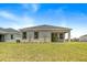 A well-manicured lawn and covered patio create an inviting backyard retreat for relaxation and entertainment at 1257 Champions Dr, Daytona Beach, FL 32124