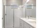 Modern bathroom featuring a glass-enclosed shower, double vanity, and neutral color palette at 1257 Champions Dr, Daytona Beach, FL 32124