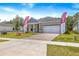 Charming single-story home featuring a brick driveway, two-car garage, and landscaped front yard at 1257 Champions Dr, Daytona Beach, FL 32124
