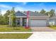 Attractive single-story home with a two-car garage, brick driveway, and well-maintained landscaping at 1257 Champions Dr, Daytona Beach, FL 32124