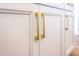 Close-up highlighting sleek white cabinets with modern gold hardware and trim, adding a touch of elegance at 1257 Champions Dr, Daytona Beach, FL 32124