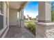Covered front porch showcasing stone accents, brick flooring, and exterior columns at 1257 Champions Dr, Daytona Beach, FL 32124