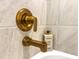 Close-up of a modern bronze shower faucet against a tiled wall, emphasizing the bathroom's luxurious details at 1257 Champions Dr, Daytona Beach, FL 32124