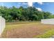 A view of the backyard with a vinyl privacy fence and lush green trees in the background at 1267 Berry Ln, Davenport, FL 33837