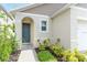 Inviting front entrance with a blue door, complemented by tasteful landscaping and a welcoming pathway at 1267 Berry Ln, Davenport, FL 33837