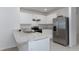 Well-lit kitchen with white cabinets, modern stainless steel appliances, and light countertops at 1267 Berry Ln, Davenport, FL 33837