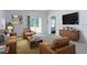 Comfortable living room features stylish leather furniture, a mounted TV, and a sliding door to the exterior at 1267 Berry Ln, Davenport, FL 33837