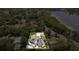 Aerial view showcasing an estate with a pool, surrounded by lush greenery and a lake nearby at 1327 Bridgeport Dr, Winter Park, FL 32789