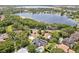 Stunning aerial view of lakeside home, lush greenery, and inviting pool, making it perfect for relaxation at 1327 Bridgeport Dr, Winter Park, FL 32789