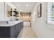 Elegant bathroom featuring a double vanity with modern fixtures, floating shelves, and a luxurious soaking tub at 1327 Bridgeport Dr, Winter Park, FL 32789
