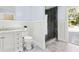 Stylish bathroom with a white vanity, marble countertop, modern fixtures, and a glass-enclosed shower with backyard access at 1327 Bridgeport Dr, Winter Park, FL 32789