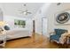 Bright bedroom featuring wood floors, a ceiling fan, and ensuite bathroom and walk-in closet at 1327 Bridgeport Dr, Winter Park, FL 32789
