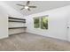 Bright bedroom boasts carpeted flooring, fan, built-in shelving, and a large window at 1327 Bridgeport Dr, Winter Park, FL 32789