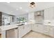 Modern kitchen with white cabinetry, stainless steel appliances, and a stylish backsplash at 1327 Bridgeport Dr, Winter Park, FL 32789