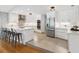 Open kitchen featuring white cabinetry, stainless steel appliances, a large island, and stylish pendant lighting at 1327 Bridgeport Dr, Winter Park, FL 32789
