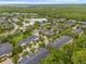 Serene aerial view of a residential area featuring lush trees, a lake, and well-maintained homes at 14025 Oasis Springs Ln # 901, Windermere, FL 34786