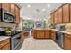 Well-lit kitchen boasts stainless steel appliances, wood cabinets, and a view into the dining room at 14025 Oasis Springs Ln # 901, Windermere, FL 34786